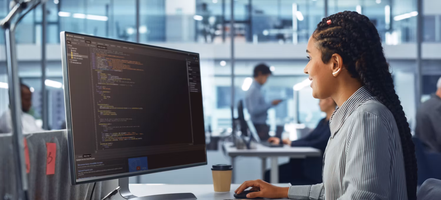 Web developer focused on coding a complex website on a laptop, surrounded by programming books and coffee mugs.